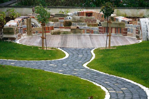 Professionell angelegte Terrasse mit Natursteinmauer und Pflasterarbeiten im Gartenbau